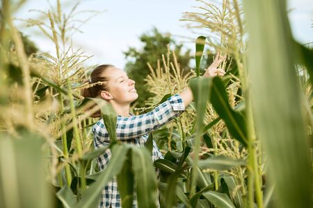 Young farmer working at her garden in sunny day. Woman engaged in the cultivation of eco friendly...