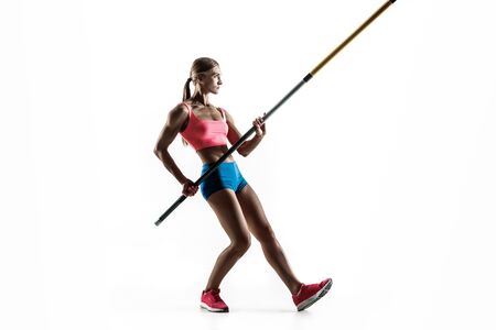 Power and beauty and purity. Professional female pole vaulter training on white studio background. Fit and slim female model practicing. Concept of sport, healthy lifestyle, action, movement, motion.の写真素材
