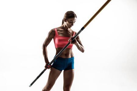 Power and beauty and purity. Professional female pole vaulter training on white studio background. Fit and slim female model practicing. Concept of sport, healthy lifestyle, action, movement, motion.の写真素材