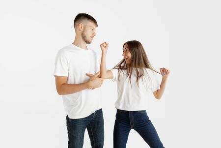 Beautiful young couples portrait isolated on white studio background. Facial expression, human emotions, advertising concept. Copyspace. Woman and man dancing and smiling, pointing, look cool.の写真素材