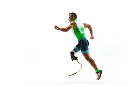 Athlete with disabilities or amputee isolated on white studio background. Professional male runner with leg prosthesis training and practicing in studio. Disabled sport and healthy lifestyle concept.の写真素材