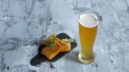 Glass of light beer on white stone background. Cold alcohol drink and meat snacks are prepared for a big friends party. Concept of drinks, fun, food, celebrating, meeting, oktoberfest.の写真素材