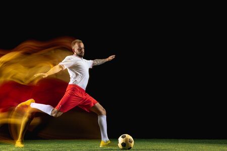 Winner. Young caucasian male football or soccer player in sportwear and boots kicking ball for the...