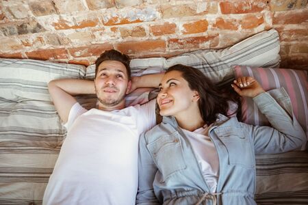 Young couple moved to a new house or apartment. Lying together, relaxing after cleaning and...