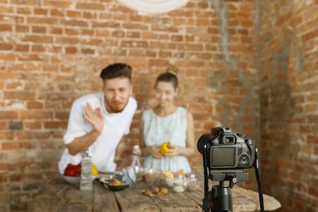 Vlogger and blogger freelance job, food concept. Young caucasian couple cooking together and...