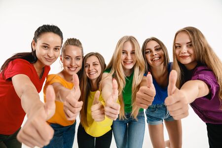 Young women wearing in LGBT flag colors isolated on white background. Caucasian female models in bright shirts. Look happy, showing thumbs up.の写真素材
