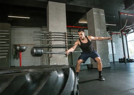 A muscular male athlete doing workout at the gym. Gymnastics, training, fitness workout flexibility....