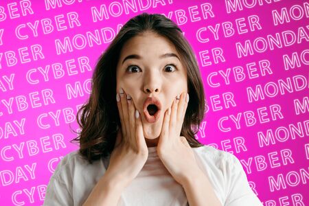 Portrait of young asian woman on pink background with neon lettering. Shocked, astonished, wondered. Concept of sales, black friday, cyber monday, finance, business. Online shops and payments bill.の写真素材