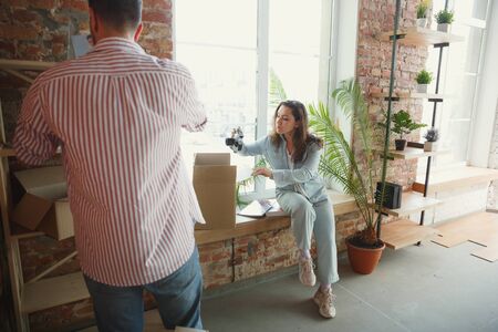 New life. Young couple moved to a new house or apartment. Look happy and confident. Family, moving,...