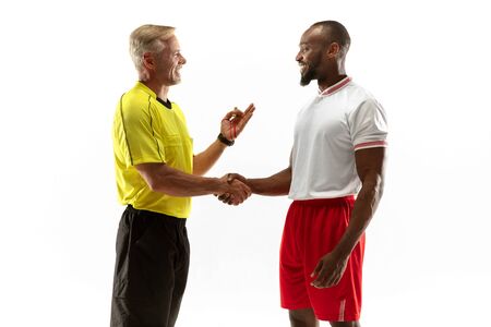 Referee gives directions with gestures to football or soccer players while gaming isolated on white studio background. Concept of sport, rules violation, controversial issues, obstacles overcoming.の写真素材