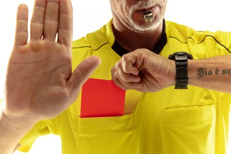 Referee showing a red card to a displeased football or soccer player while gaming isolated on white studio background. Concept of sport, rules violation, controversial issues, obstacles overcoming.の写真素材