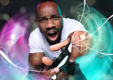 Passioned for winning. Young man holding a video game controller isolated on colorful background....