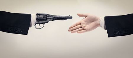 Be careful in your communication. Two male hands shaking in black suit on brown studio