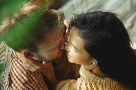 Couple of lovers at home relaxing together. Caucasian man and woman having weekend, looks tender and happy. Concept of relations, family, autumn and winter comfort. Domestic romantic.の写真素材