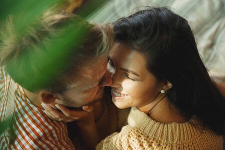 Couple of lovers at home relaxing together. Caucasian man and woman having weekend, looks tender and...