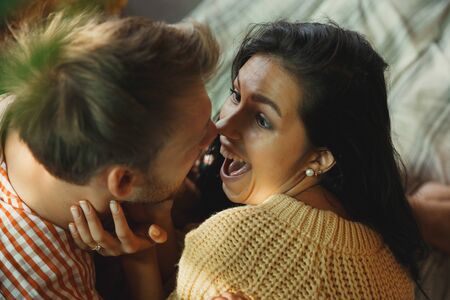 Couple of lovers at home relaxing together. Caucasian man and woman having weekend, looks tender and happy. Concept of relations, family, autumn and winter comfort. Domestic romantic.の写真素材