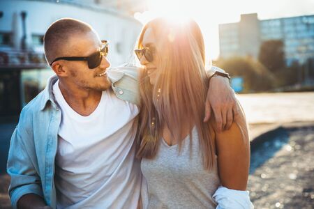 Tanned young caucasian couple, modern lovestory in film grain effect and vintage style. Sunset....