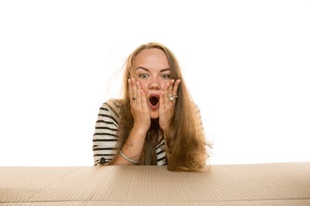 Young astonished woman opening the biggest postal package isolated on white. Shocked female model on...