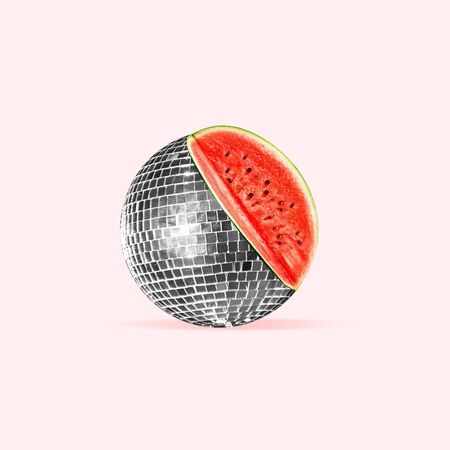Unusual combination of usual things. Disco ball as an watermelon on trendy coral background. Negative space. Modern design. Copyspace. Contemporary art. Creative conceptual and colorful collage.の写真素材