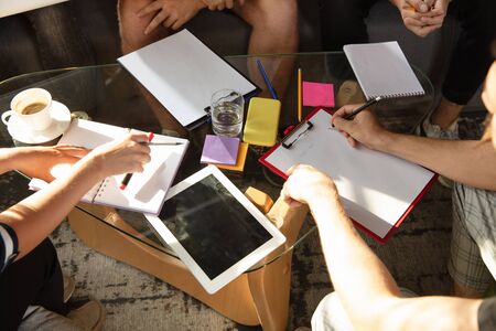 Group of young caucasian office workers meeting to discuss new ideas. Creative meeting. Teamwork and brainstorming. Men and women meet in office to plan their future working. Business concept.の写真素材