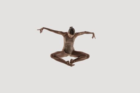 Modern ballet dancer. Contemporary art ballet. Young flexible athletic woman.. Studio shot isolated on white background. Negative space.の写真素材