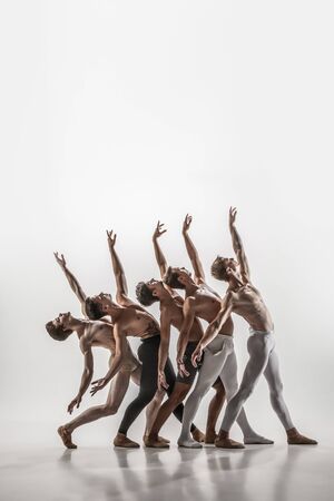 The group of modern ballet dancers. Contemporary art ballet. Young flexible athletic men and women in ballet tights. Studio shot isolated on white background. Negative space.の写真素材