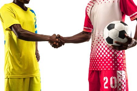 Professional african-american football or soccer players in play isolated on white studio background. Fit man in action, excitement, emotional moment. Concept of movement at gameplay, cheering, teamwork.の写真素材