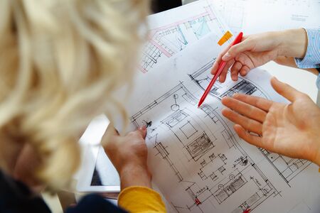 Interior designer working with young couple. Lovely family and professional designer or architector...