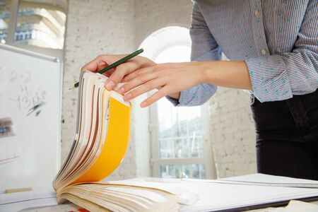 Professional interior designer or architector working with colour palette, room drawings in modern...