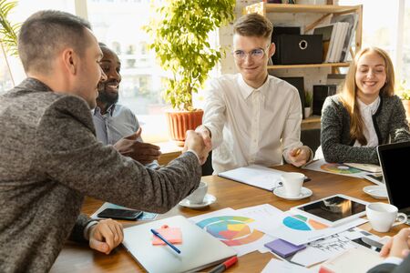 Group of young business professionals having a meeting. Diverse group of coworkers discuss new...