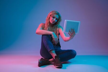 Caucasian young womans portrait on gradient background in neon light. Beautiful female model with...