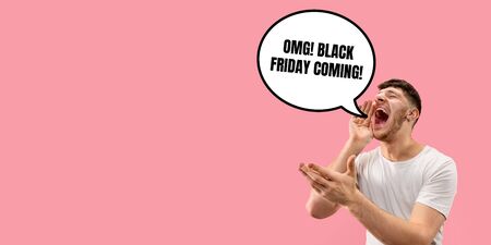 Half-length close up portrait of young man on coral background. The human emotions, black friday, cyber monday, purchases, sales concept. Trendy colors. Negative space. Screaming, crazy happyの写真素材
