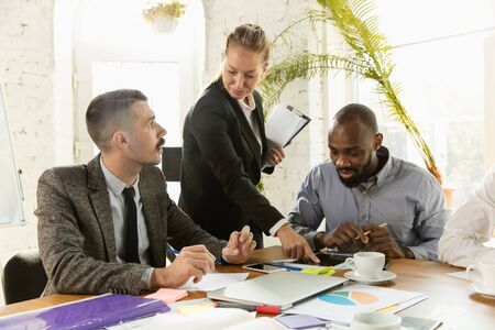 Group of young business professionals having a meeting. Diverse group of coworkers discuss new...