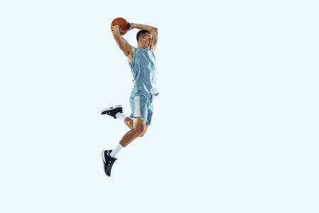 High flight. Young caucasian basketball player of team in action, motion in jump isolated on white...