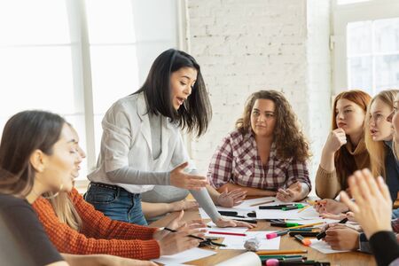 Teamwork. Young people discussing about women rights and equality at the office. Caucasian businesswomen or office workers have meeting about problem in workplace, male pressure and harassment.の写真素材