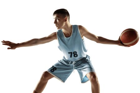 Full length portrait of young basketball player with a ball isolated on white studio background. Teenager training and practicing in action, motion. Concept of sport, movement, healthy lifestyle, ad.の写真素材