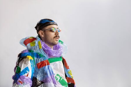 Close up of man wearing plastic on white background. Male model in clothes made of garbage. Fashion, style, recycling, eco and environmental concept. Too much pollution, were eating and taking it.の写真素材