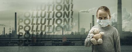 Caucasian little girl wearing the respiratory protection mask against air pollution, dust particles exceed the safety limits because of fuming factories. Healthcare, environmental, ecology concept.の写真素材