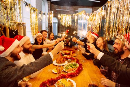 Young caucasian people in celebrate attire talk, drink wine, cheers.の写真素材