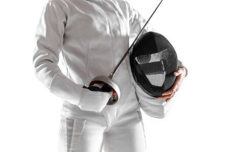Teen girl in fencing costume with sword in hand isolated on white studio background. Young female...
