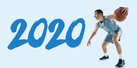 2020 Year meeting. Young caucasian basketball player in action, motion in jump isolated on blue...