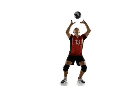Young caucasian volleyball player placticing isolated on white background. Male sportsman training with the ball in motion and action. Sport, healthy lifestyle, activity, movement concept. Copyspace.の写真素材