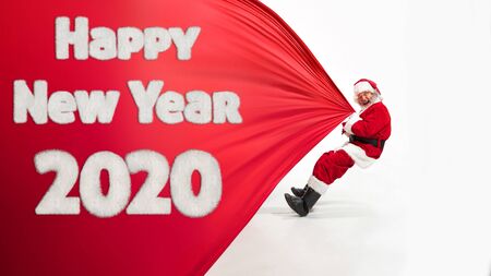 Santa Claus isolated on white studio background. Caucasian male model in traditional costume with Christmas tree. Concept of 2020 New Years, winter mood, holidays. Copyspace, flyer, postcard.の写真素材