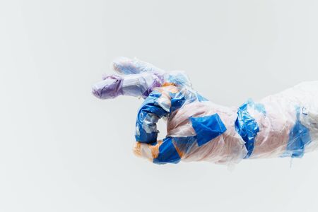 Big plastic hand made of garbage isolated on white studioの写真素材