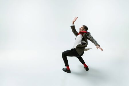 Young caucasian man moving flexible on white studioの写真素材
