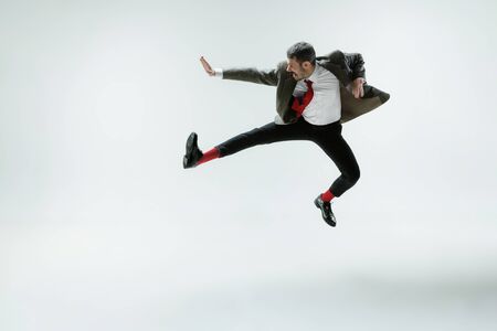 Young caucasian man moving flexible on white studioの写真素材