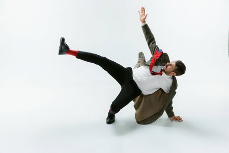 Young caucasian man moving flexible on white studioの写真素材