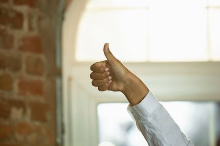 Close up of african-american humans hands gesturing. Showing the sign of nice, thumb up. Business,...