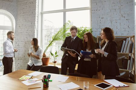 Get right way. Group of young business professionals having a meeting. Diverse group of coworkers discuss new decisions, plans, results, strategy. Creativity, workplace, business, finance, teamwork.の写真素材