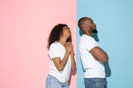 Woman apologizing. Young emotional man and woman in casual clothes on pink and blue bicolored...